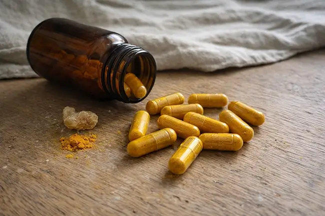 Kurkuma en boswellia capsules voor gewrichtsondersteuning op een houten achtergrond