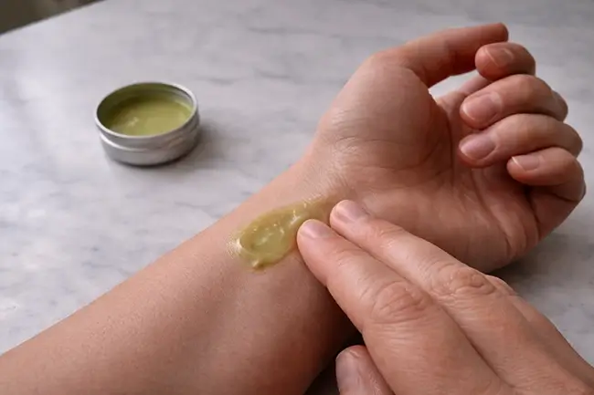 Persoon brengt CBD zalf aan op pols en gewrichten voor verlichting van ontsteking