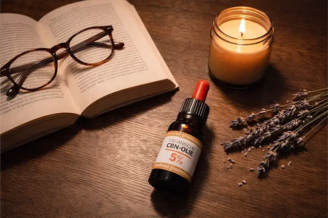 Ontspannen avondritueel met CBN olie flesje naast een boek en kaars