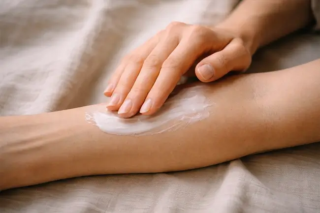 Close-up van handen die cbd creme aanbrengen op de onderarm