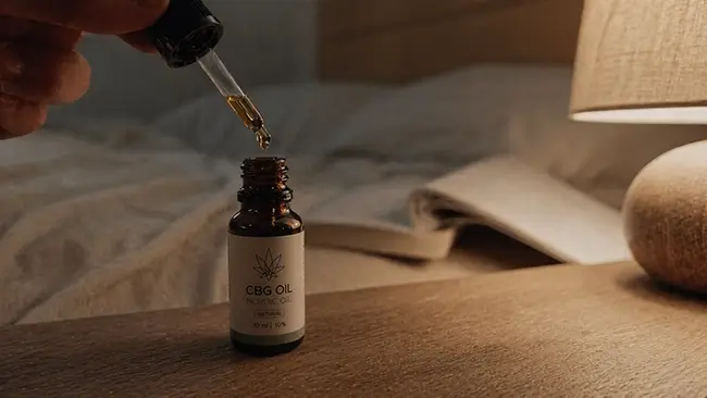 Pipet met CBG olie boven een glazen flesje, klaar voor inname voor het slapen