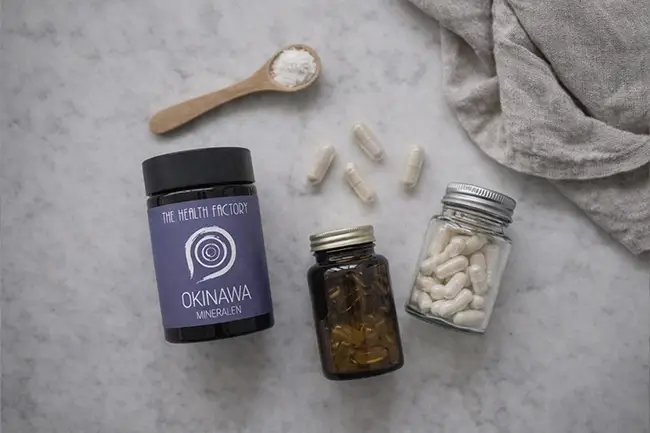 Diverse supplementen en Okinawa mineralen poeder op een lichte achtergrond