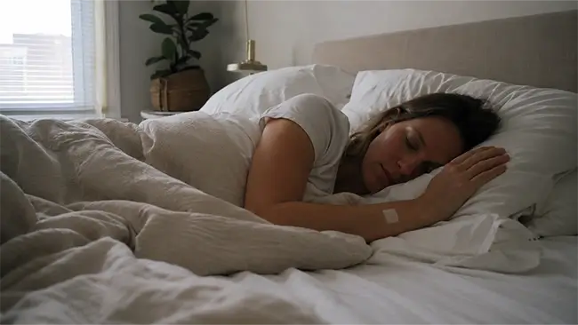Vrouw slaapt rustig en diep in haar bed na het opplakken van een slaappleister