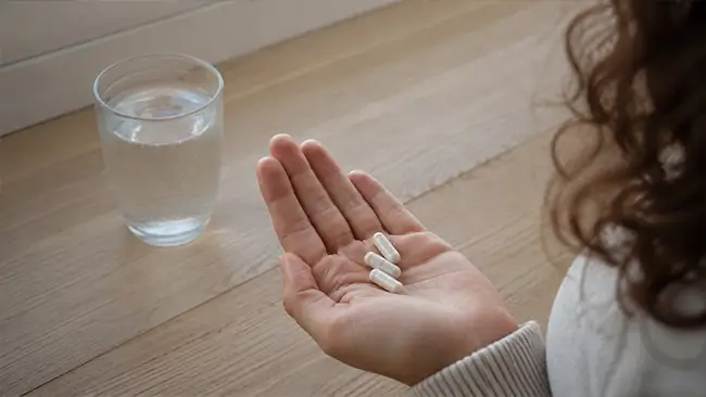 Capsules met magnesium bisglycinaat in de hand