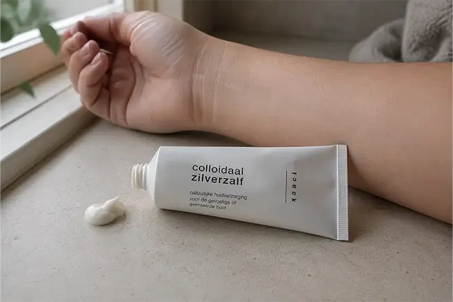tube colloïdaal zilverzalf naast schone huid